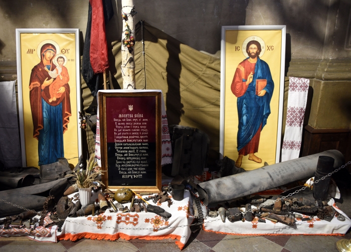 A picture shows military ammunition and Christian icons layed at a monument to fallen soldiers outside the Saints Peter and Paul Garrison Church in the western Ukrainian city of Lviv on March 7, 2022, 12 days after Russia launched a military invasion on Ukraine. (Photo by YURIY DYACHYSHYN/AFP via Getty Images)