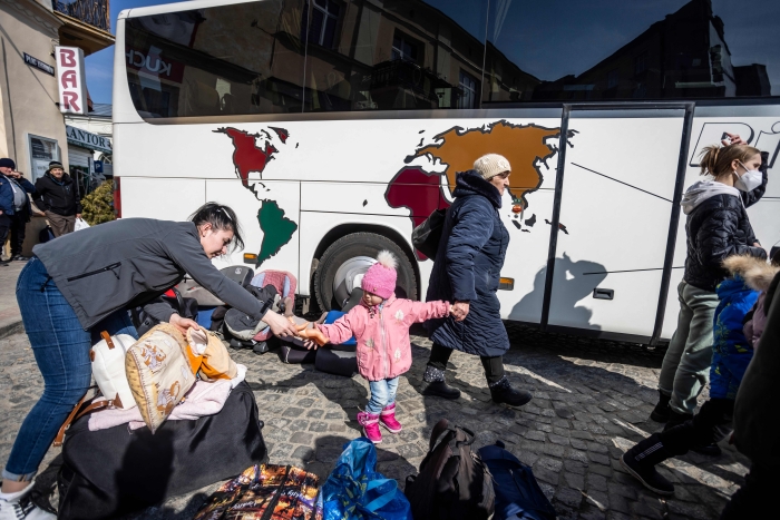 Refugees from Ukraine prepare to board a free bus which will take them to Germany, in front of railway station in Przemysl, southeastern Poland, on March 20, 2022. - Ten million people -- more than a quarter of the population -- have now fled their homes in Ukraine since Russia's invasion on February 24, 2022. (Getty Images)