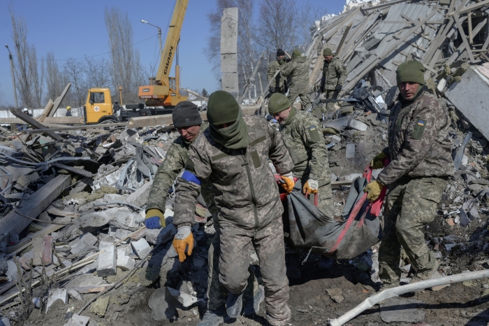 Ukrainian soldiers carry a dead soldier through debris at the military school hit by Russian rockets the day before, in Mykolaiv, southern Ukraine, on March 19, 2022. (Getty Images)