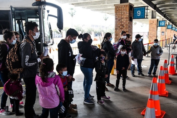 Migrants, mostly from Central America, are dropped off by the US Customs and Border Protection at a bus station near the Gateway International Bridge, in Brownsville, Texas. President Biden's pledge of a more humane approach has sparked a rush to the border. (Photo by CHANDAN KHANNA/AFP via Getty Images)