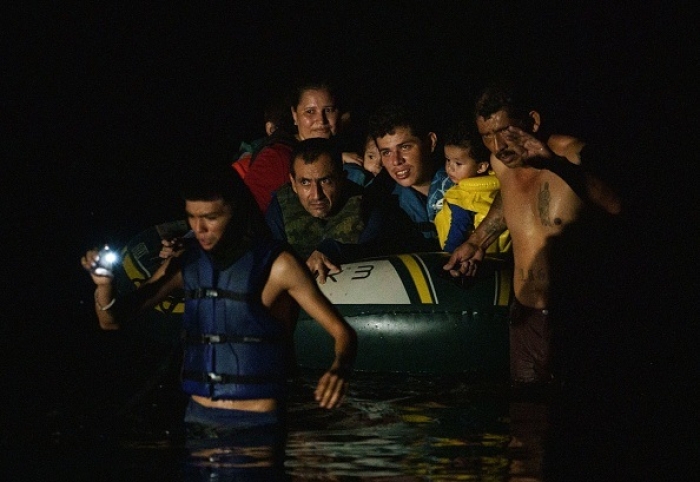 Human smugglers pull illegal immigrants into the United States in Roma, Texas on July 8, 2021. (Photo by PAUL RATJE/AFP via Getty Images)