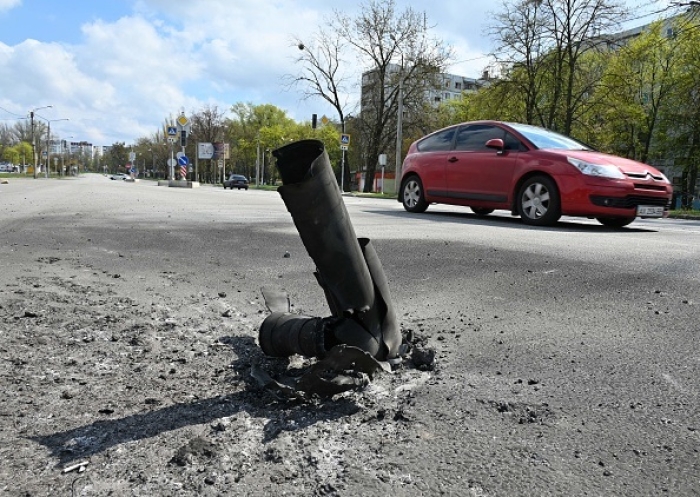 A car passes a missile embedded in a residential area after recent Russian shelling in the northern outskirts of Kharkiv, on April 21, 2022. (Photo by SERGEY BOBOK/AFP via Getty Images)