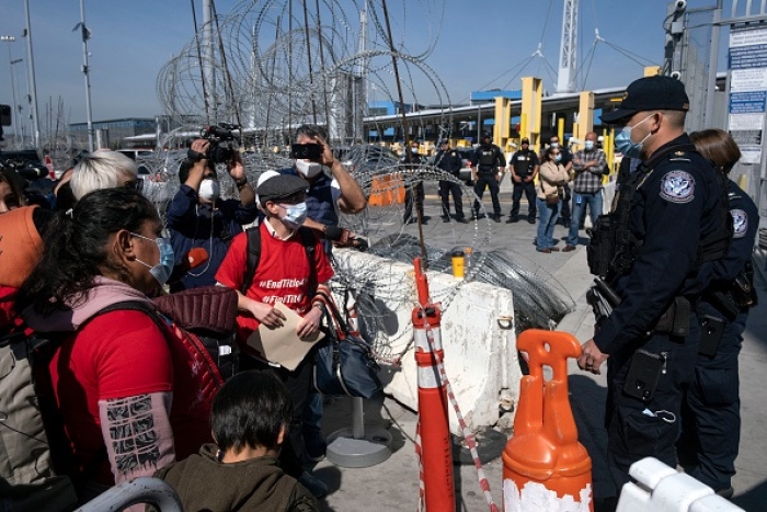 Would-be asylum seekers protest against Title 42 on the Mexican side of the San Ysidro Crossing port in Tijuana, Baja California state, Mexico, on March 21, 2022. (Photo by GUILLERMO ARIAS/AFP via Getty Images)