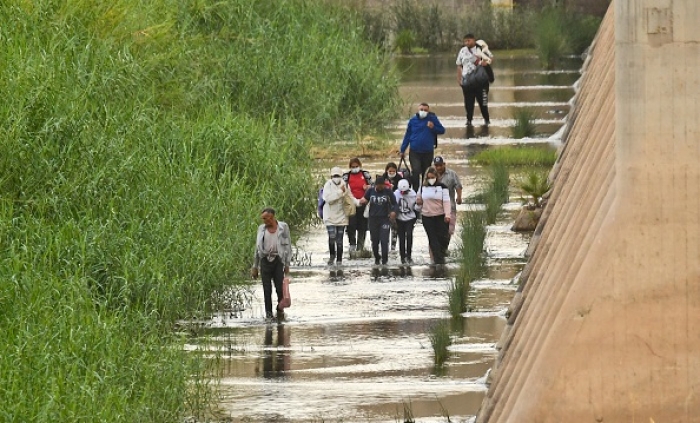 Migrants attempting to cross illegally into the U.S. from Mexico are later detained by U.S. Customs and Border Protection in San Luis, Arizona. (Photo by Nick Ut/Getty Images)