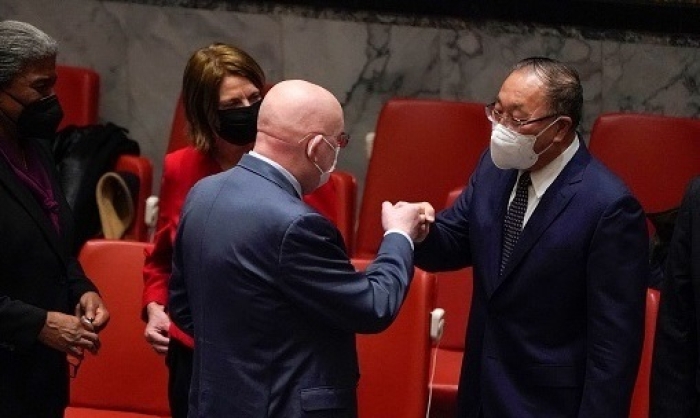 Russian Ambassador to the U.N. Vassily Nebenzia gives his Chinese counterpart, Zhang Jun, a fist bump in the Security Council chamber. (Photo by Timothy A. Clary/AFP via Getty Images)