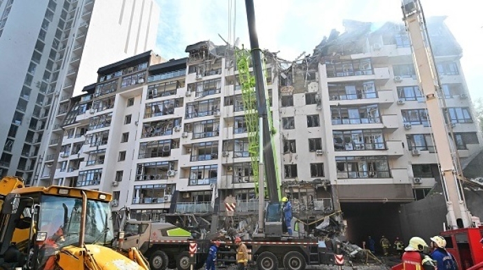 Ukrainian rescue workers at a residential building in Kyiv hit by Russian missiles on Sunday morning. (Photo by Sergei Supinsky/AFP via Getty Images)