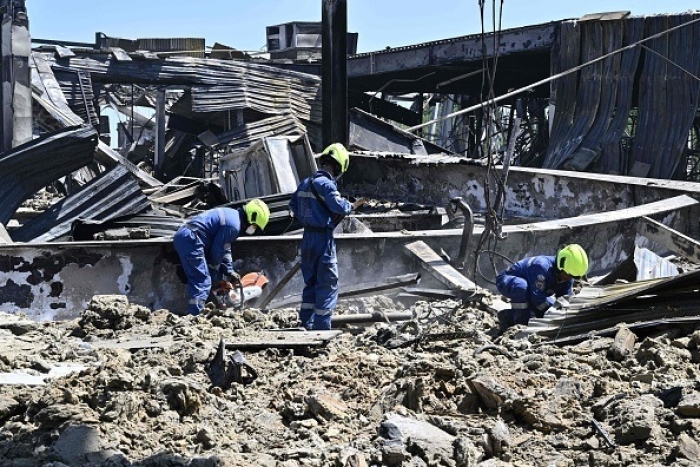 Emergency workers in the rubble at the Amstor mall in Kremenchuk, on Tuesday, a day after Ukrainian authorities say it was hit by a Russian missile, killing at least 18 people. (Photo by Genya Savilov/AFP via Getty Images)