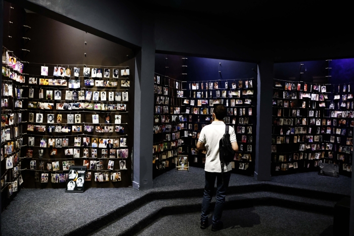 A man looks at images of victims on display at the Kigali Genocide Memorial, in Kigali on May 26, 2021, prior to the official visit of the first French head of state to Rwanda since 2010, which has long accused France of complicity in the mass killings of Rwandan Tutsis. (Getty Images)
