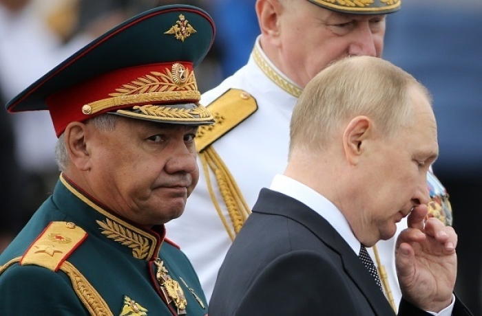 Russian President Vladimir Putin views a parade of warships in St. Petersburg on July 31, Russia’s Navy Day. With him are Defense Minister Sergei Shoigu and the commander-in-chief of the Russian Navy Nikolai Yevmenov. (Getty Images)