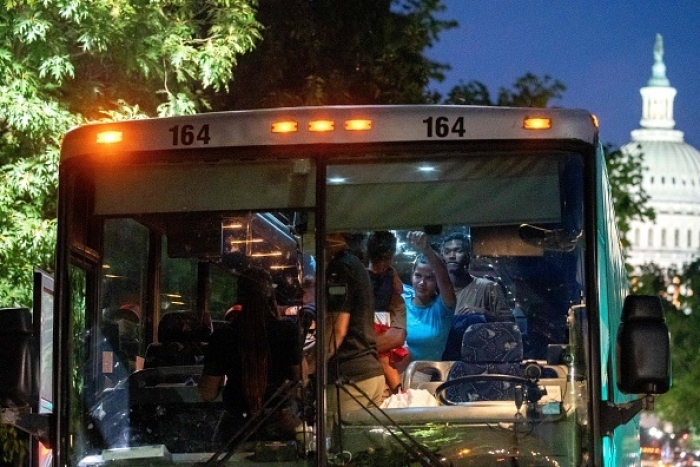 Migrants from Venezuela, who boarded a bus in Del Rio, Texas, disembark within view of the US Capitol in Washington, DC, on August 2, 2022. (Photo by STEFANI REYNOLDS/AFP via Getty Images)