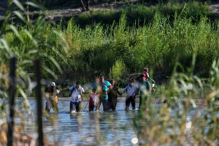 Venezuelans illegally cross the Rio Grande River in Eagle Pass, Texas on June 30, 2022. (Photo by CHANDAN KHANNA/AFP via Getty Images)
