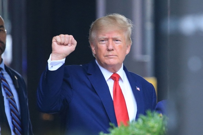 Former President Donald Trump raises his fist while walking to a vehicle outside of Trump Tower in New York City on August 10, 2022. (Photo by STRINGER/AFP via Getty Images)