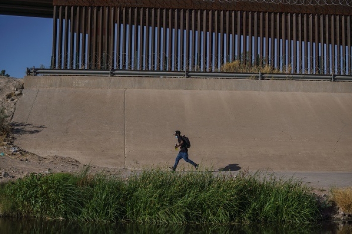A migrant runs along the border wall in El Paso, Texas, last May. Nearly 2.4 million migrant “encounters” were reported on the southwest border during fiscal year 2022, which ended on September 30. (Photo by Paul Ratje / AFP via Getty Images) A migrant runs along the border wall in El Paso, Texas, last May. Nearly 2.4 million migrant “encounters” were reported on the southwest border during fiscal year 2022, which ended on September 30. (Photo by Paul Ratje / AFP via Getty Images)