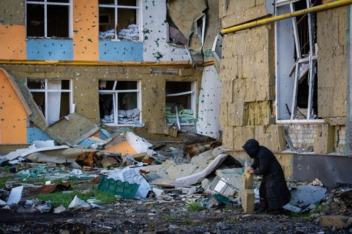 A Ukrainian woman removes a piece of wall insulation from a war-ravaged building in Izium to use to warm her house as winter approaches. (Photo by Scott Peterson / Getty Images) A Ukrainian woman removes a piece of wall insulation from a war-ravaged building in Izium to use to warm her house as winter approaches. (Photo by Scott Peterson / Getty Images)