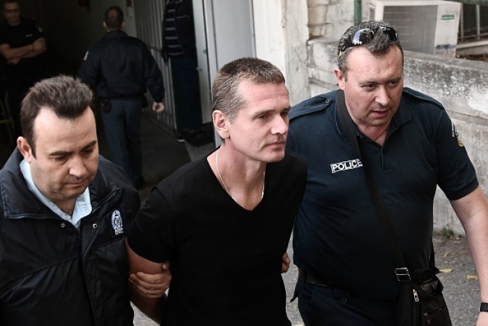 Russian citizen Alexander Vinnik is escorted by Greek police officers to a courthouse in Thessaloniki in 2017. Vinnik was extradited to the U.S. over the summer and is facing trial in San Francisco on charges relating to cybercrime money laundering. (Photo by Sakis Mitrolidis / AFP via Getty Images) Russian citizen Alexander Vinnik is escorted by Greek police officers to a courthouse in Thessaloniki in 2017. Vinnik was extradited to the U.S. over the summer and is facing trial in San Francisco on charges relating to cybercrime money laundering. (Photo by Sakis Mitrolidis / AFP via Getty Images)
