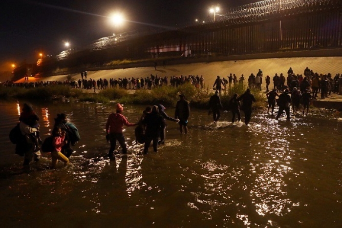 Migrants travelling in a caravan of more than a thousand people from Nicaragua, Peru, Ecuador, Colombia, Venezuela and the Dominican Republic cross into El Paso, Texas on December 11, 2022. (Photo by HERIKA MARTINEZ/AFP via Getty Images) Migrants travelling in a caravan of more than a thousand people from Nicaragua, Peru, Ecuador, Colombia, Venezuela and the Dominican Republic cross into El Paso, Texas on December 11, 2022. (Photo by HERIKA MARTINEZ/AFP via Getty Images)