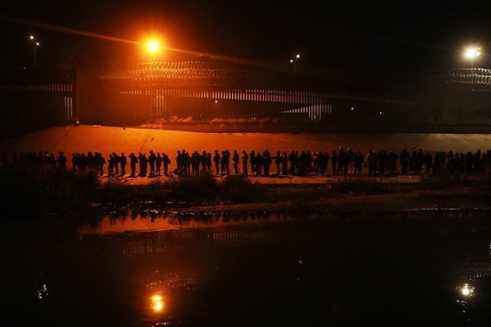 A line of illegal border-crossers stretches as far as the eye can see as they await processing in El Paso, Texas on Dec. 11, 2022. (Photo by HERIKA MARTINEZ/AFP via Getty Images)