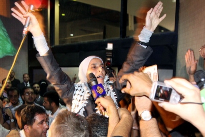 Unrepentant freed terrorist Ahlam al-Tamimi waves to supporters as she arrives in Amman, Jordan, in October 2011. (Photo by Louai Beshara / AFP via Getty Images)