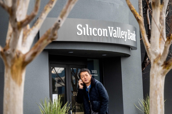 A pedestrian speaks on a mobile telephone as he walks past Silicon Valley Banks headquarters in Santa Clara, California on March 10, 2023.  (Getty Images)  