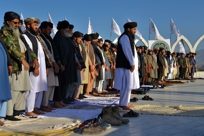 Members of the Taliban offer prayers at a flag hoisting ceremony in Kabul in March 2022. (Photo by Ahmad Sahel Arman / AFP via Getty Images)