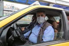 An Iranian taxi driver sits inside a transparent partition to isolate himself from passengers at Aryashahr station, a transport hub in west Tehran on April 26, 2020, as cab services have been among the hardest hit since the country's coronavirus outbreak. (Photo credit: ATTA KENARE/AFP via Getty Images)