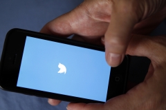 A man opens the Twitter app on his phone. (Photo credit: Chesnot/Getty Images)