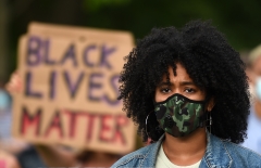A protester wearing a protective face mask attends a gathering in support of the Black Lives Matter movement. (Photo credit: OLI SCARFF/AFP via Getty Images)