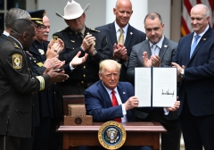 President Donald Trump shows his signature on an Executive Order on Safe Policing for Safe Communities. (Photo credit: SAUL LOEB/AFP via Getty Images)