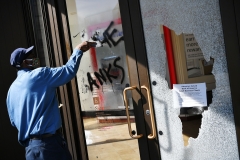 A man repairs destruction left by the riots. (Photo credit: MANDEL NGAN/AFP via Getty Images)