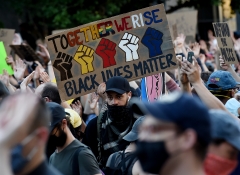 Demonstrators protesting the death of George Floyd hold up placards near Lafayette park accross the White House on June 2, 2020 in Washington, D.C. (Photo credit: OLIVIER DOULIERY/AFP via Getty Images)