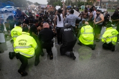 Police officers and demonstrators kneel together during a protest against police brutality and the recent death of George Floyd. (Photo credit: EVA MARIE UZCATEGUI/AFP via Getty Images)