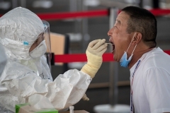 A Beijing resident is tested for COVID-19 last week, after several new domestic cases were reported in the Chinese capital. (Photo by Nicolas Asfouri/AFP via Getty Images)