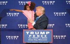Republican presidential nominee Donald Trump holds a child as he speaks during a rally at the KI Convention Center on October 17, 2016 in Green Bay, Wisc. (Photo credit: TASOS KATOPODIS/AFP via Getty Images)