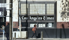 Pedestrians walk past the Los Angeles Times office building. (Photo credit: FREDERIC J. BROWN/AFP via Getty Images)
