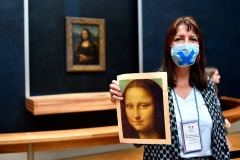 With the Mona Lisa in the background, a Louvre employee prepares to welcome returning visitors this week. (Photo by Aurelien Meunier/Getty Images)