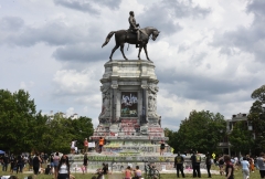 Protesters climb on the base of the statue of Confederate General Robert E. Lee on Monument Avenue on June 6, 2020 in Richmond, Va. (Photo credit: Vivien Killilea/Getty Images)