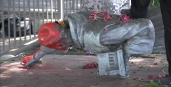 A protester steps on top of a toppled statue of St. Junípero Serra in Los Angeles, Calif. (Photo credit: YouTube/ABC7)
