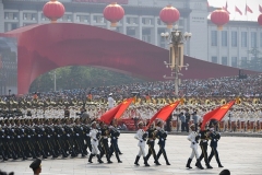 Chinese soldiers march with the national flag, flanked by the flags of the Communist Party of China and the People's Liberation Army during a military parade at Tiananmen Square in Beijing on October 1, 2019. (Photo by GREG BAKER/AFP via Getty Images)