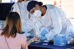 A person undergoes a finger prick blood sample as part of a coronavirus antibody rapid serological test on July 26, 2020 in San Dimas, California. (Photo by ROBYN BECK/AFP via Getty Images)