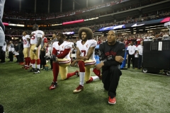 Colin Kaepernick #7 and Eric Reid #35 of the San Francisco 49ers kneel on the sideline, during the anthem, prior to the game against the Atlanta Falcons at the Georgia Dome on December 18, 2016 in Atlanta, Ga. (Photo credit: Michael Zagaris/San Francisco 49ers/Getty Images)