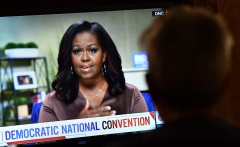 A person watches former First Lady Michelle Obama speak during the opening night of the Democratic National Convention. (Photo credit: CHRIS DELMAS/AFP via Getty Images)