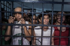 Prisoners stand behind bars. (Photo credit: Giles Clarke/Contributor/Getty Images)