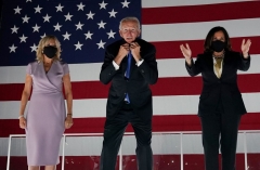 Former vice-president and Democratic presidential nominee Joe Biden briefly removes his mask as he greets supporters alond with his wife Jill Biden and Senator from California and Democratic vice presidential nominee Kamala Harris outside the Chase Center in Wilmington, Delaware, at the conclusion of the Democratic National Convention, held virtually amid the novel coronavirus pandemic, on August 20, 2020. (Photo by OLIVIER DOULIERY/AFP via Getty Images)