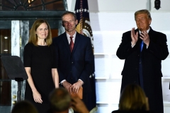 President Donald Trump applauds after Supreme Court Associate Justice Clarence Thomas (out of frame) swore in Judge Amy Coney Barrett as a US Supreme Court Associate Justice, flanked by her husband Jesse M. Barrett, during a ceremony on the South Lawn of the White House October 26, 2020, in Washington, DC. (Photo by BRENDAN SMIALOWSKI/AFP via Getty Images)