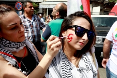 A woman gets sickle and hammer face paint. (Photo credit: ANWAR AMRO/AFP via Getty Images)