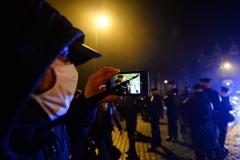A man films police officers during a demonstration in the city of Nantes against the draft “global security” legislation. (Photo by Jean-Francois Monier/AFP via Getty Images)