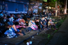 Honduran migrants, part of a caravan heading to the US, rest on a sidewalk in Entre Rios, Guatemala, after they crossed the border from Honduras on October 1, 2020.(Photo by JOHAN ORDONEZ/AFP via Getty Images)