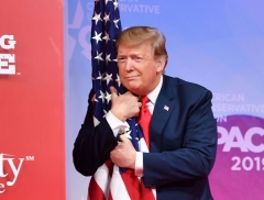 President Donald Trump hugs the US flag as he arrives to speak at the annual Conservative Political Action Conference (CPAC) in National Harbor, Maryland, on March 2, 2019. (Photo by NICHOLAS KAMM/AFP via Getty Images)