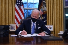 Joe Biden signs executive orders after the inauguration. (Photo credit: JIM WATSON/AFP via Getty Images)