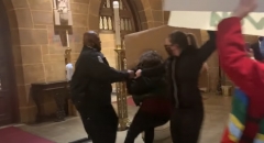 A security guard attempts to remove a pro-abortion protester from the cathedral. (Photo credit: YouTube/TheColumbusDispatch)